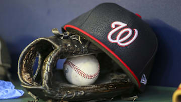 Apr 11, 2022; Atlanta, Georgia, USA; A detailed view of a Washington Nationals hat and glove in the dugout before a game against the Atlanta Braves at Truist Park. Mandatory Credit: Brett Davis-Imagn Images