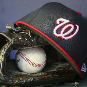 Apr 11, 2022; Atlanta, Georgia, USA; A detailed view of a Washington Nationals hat and glove in the dugout before a game against the Atlanta Braves at Truist Park. Mandatory Credit: Brett Davis-Imagn Images