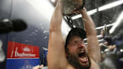 Los Angeles Dodgers pitcher Clayton Kershaw (22) celebrates in the clubhouse with the Commissioner's Trophy after defeating the Toronto Blue Jays in the 2025 MLB World Series at Rogers Centre on Saturday.