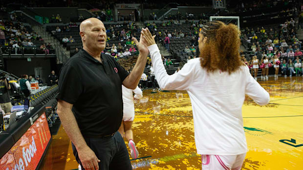 elly Graves high-fives his team before their game against USC at Matthew Knight Arena