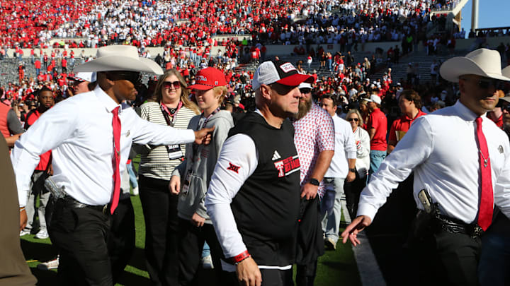Nov 8, 2025; Lubbock, Texas, USA;  Texas Tech Red Raiders head coach Joey McGuire is escorted off the field after fans stormed the field at the conclusion of the game against the Brigham Young Cougars at Jones AT&T Stadium. Mandatory Credit: Michael C. Johnson-Imagn Images