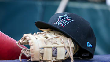 Apr 24, 2024; Atlanta, Georgia, USA; A detailed view of a Miami Marlins hat and glove in the dugout before a game against the Atlanta Braves at Truist Park. 
