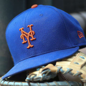 Jul 13, 2022; Atlanta, Georgia, USA; A detailed view of a New York Mets hat and glove in the dugout against the Atlanta Braves in the eighth inning at Truist Park. Mandatory Credit: Brett Davis-Imagn Images