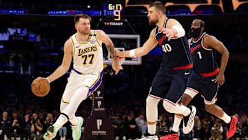 Mar 2, 2025; Los Angeles, California, USA; Los Angeles Lakers guard Luka Doncic (77) dribbles against LA Clippers center Ivica Zubac (40) and guard James Harden (1) during the second quarter at Crypto.com Arena. Mandatory Credit: Jason Parkhurst-Imagn Images