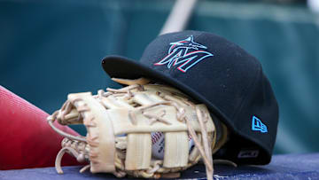 Apr 24, 2024; Atlanta, Georgia, USA; A detailed view of a Miami Marlins hat and glove in the dugout before a game against the Atlanta Braves at Truist Park. 