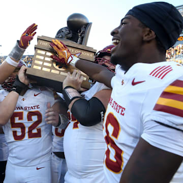 Iowa State players celebrate with the Cy-Hawk trophy after defeating Iowa Saturday, Sept. 7, 2024 at Kinnick Stadium in Iowa City, Iowa.