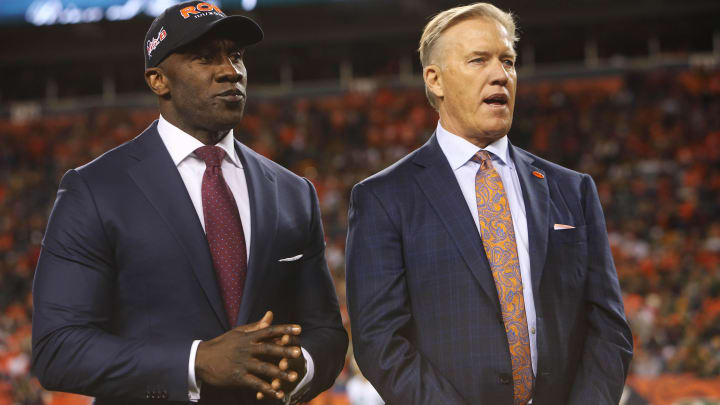Nov 1, 2015; Denver, CO, USA; Denver Bronco former tight end Shannon Sharpe and former Broncos quarterback and current general manager John Elway during a ceremony inducting owner Pat Bowlen (not pictured) into the Broncos Ring of Fame during halftime between the Denver Broncos and the Green Bay Packers at Sports Authority Field at Mile High. The Broncos won 29-10. Mandatory Credit: Chris Humphreys-USA TODAY Sports