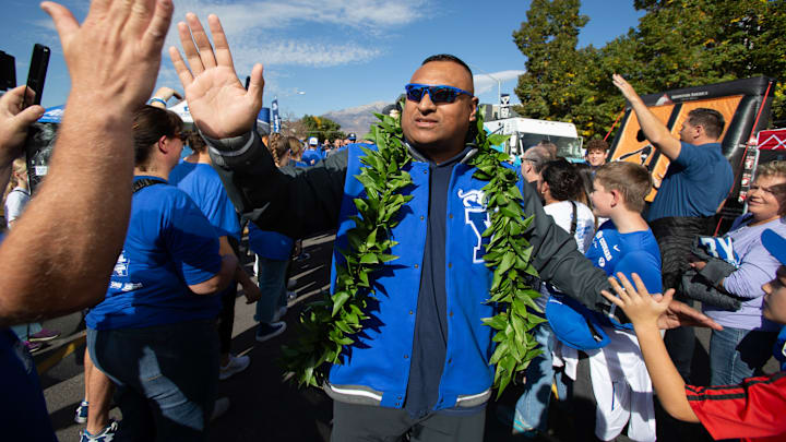 Kalani Sitake high-fives fans as BYU football approaches the stadium.