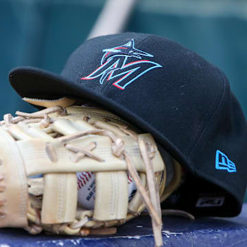 Apr 24, 2024; Atlanta, Georgia, USA; A detailed view of a Miami Marlins hat and glove in the dugout before a game against the Atlanta Braves at Truist Park. Mandatory Credit: Brett Davis-Imagn Images