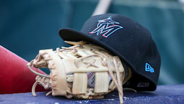 Apr 24, 2024; Atlanta, Georgia, USA; A detailed view of a Miami Marlins hat and glove in the dugout before a game against the Atlanta Braves at Truist Park. Mandatory Credit: Brett Davis-Imagn Images
