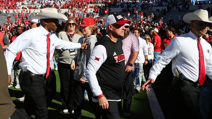 Nov 8, 2025; Lubbock, Texas, USA;  Texas Tech Red Raiders head coach Joey McGuire is escorted off the field after fans stormed the field at the conclusion of the game against the Brigham Young Cougars at Jones AT&T Stadium. Mandatory Credit: Michael C. Johnson-Imagn Images