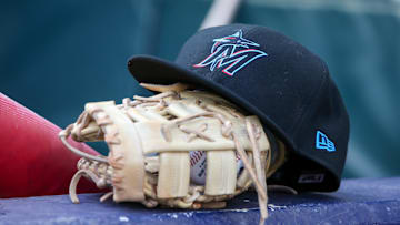 Apr 24, 2024; Atlanta, Georgia, USA; A detailed view of a Miami Marlins hat and glove in the dugout before a game against the Atlanta Braves at Truist Park.