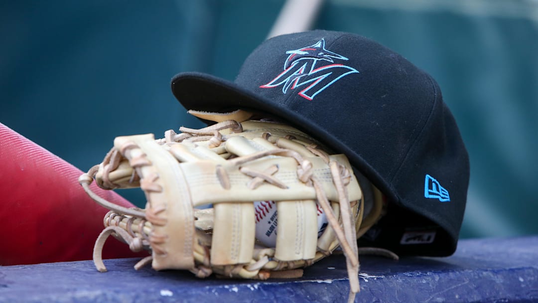 Apr 24, 2024; Atlanta, Georgia, USA; A detailed view of a Miami Marlins hat and glove in the dugout before a game against the Atlanta Braves at Truist Park.