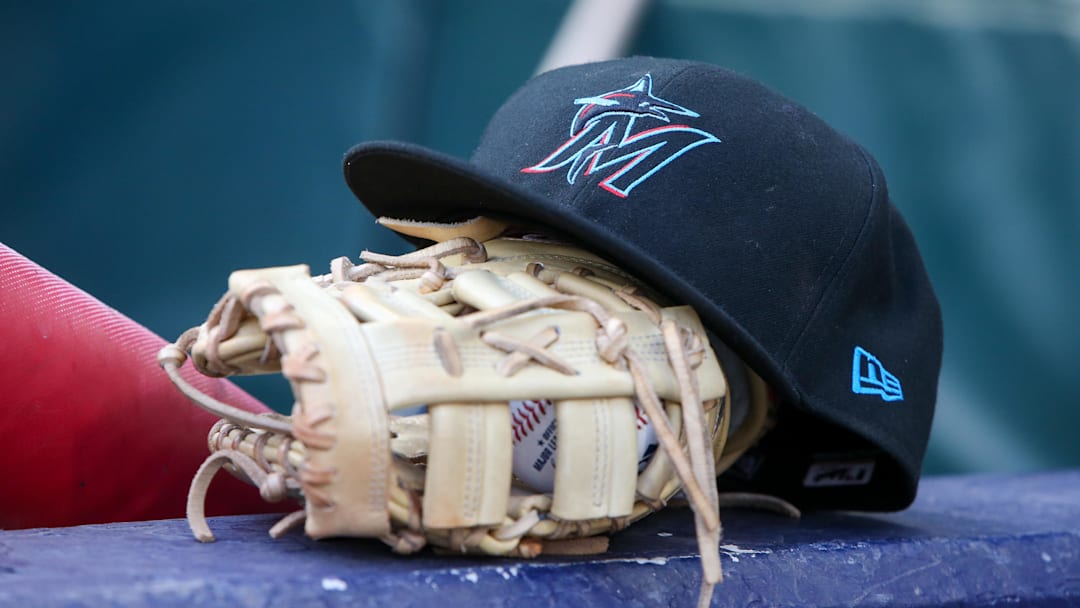Apr 24, 2024; Atlanta, Georgia, USA; A detailed view of a Miami Marlins hat and glove in the dugout before a game against the Atlanta Braves at Truist Park. 