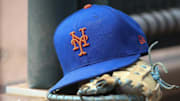 Jul 13, 2022; Atlanta, Georgia, USA; A detailed view of a New York Mets hat and glove in the dugout against the Atlanta Braves in the eighth inning at Truist Park. Mandatory Credit: Brett Davis-Imagn Images