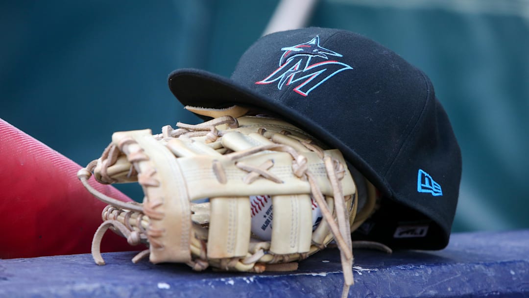 Apr 24, 2024; Atlanta, Georgia, USA; A detailed view of a Miami Marlins hat and glove in the dugout before a game against the Atlanta Braves at Truist Park. 