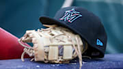 Apr 24, 2024; Atlanta, Georgia, USA; A detailed view of a Miami Marlins hat and glove in the dugout before a game against the Atlanta Braves at Truist Park.