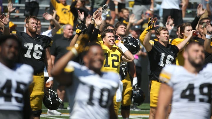 Iowa’s Tyler Elsbury (76), Cade McNamara (12) and others wave during Kids Day at Kinnick Saturday, Aug. 10, 2024 at Kinnick Stadium in Iowa City, Iowa.