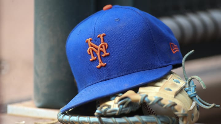 Jul 13, 2022; Atlanta, Georgia, USA; A detailed view of a New York Mets hat and glove in the dugout against the Atlanta Braves in the eighth inning at Truist Park. Mandatory Credit: Brett Davis-USA TODAY Sports