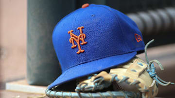 Jul 13, 2022; Atlanta, Georgia, USA; A detailed view of a New York Mets hat and glove in the dugout against the Atlanta Braves in the eighth inning at Truist Park. 