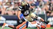 Purdue Boilermakers running back Devin Mockobee (45) jumps over an Illinois Fighting Illini defensive back 