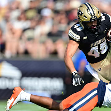 Purdue Boilermakers running back Devin Mockobee (45) jumps over an Illinois Fighting Illini defensive back 