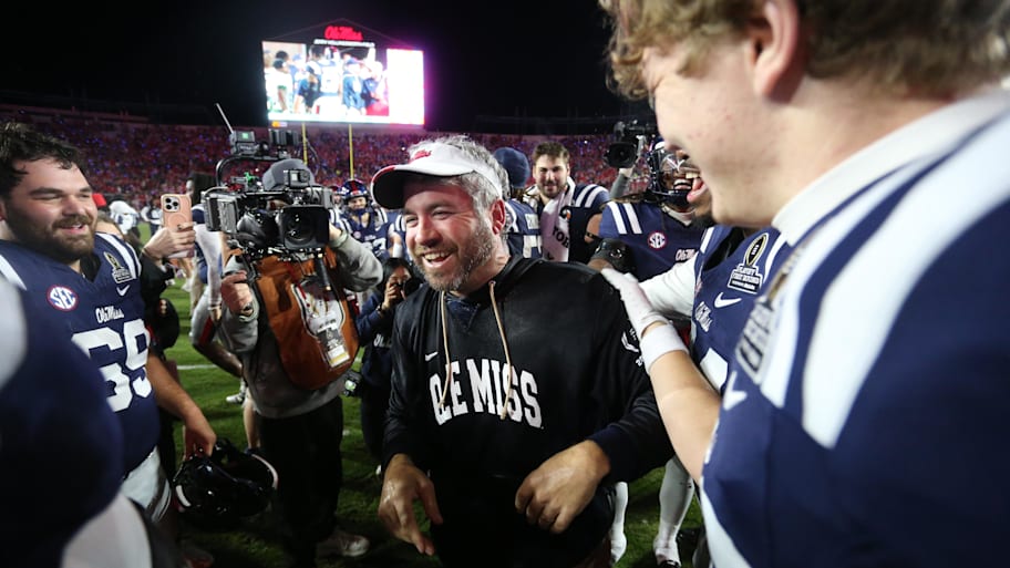 Rebels head coach Pete Golding celebrates with players after beating Tulane.