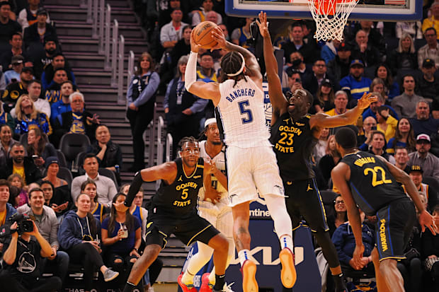 Orlando Magic forward Paolo Banchero (5) shoots the ball against Golden State Warriors forward Draymond Green (23)