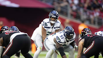 Dec 8, 2024; Glendale, Arizona, USA; Seattle Seahawks center Olu Oluwatimi (51) prepares to snap the ball to quarterback Geno Smith (7) against the Arizona Cardinals at State Farm Stadium. 