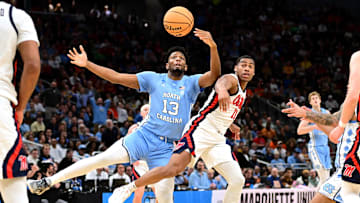 North Carolina Tar Heels forward Jalen Washington (13) and Mississippi Rebels guard Matthew Murrell (11) chase a loose ball during the first half of a first round NCAA men’s tournament game at Fiserv Forum.