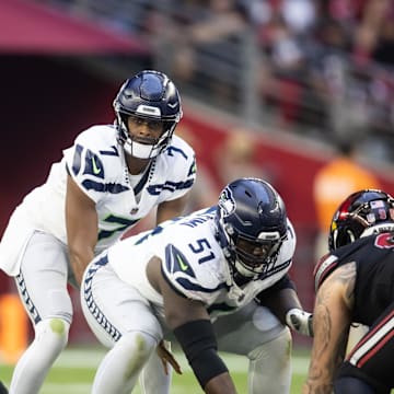 Dec 8, 2024; Glendale, Arizona, USA; Seattle Seahawks center Olu Oluwatimi (51) prepares to snap the ball to quarterback Geno Smith (7) against the Arizona Cardinals at State Farm Stadium. 