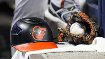 Mar 30, 2025; Toronto, Ontario, CAN; A detail view of a Baltimore Orioles batting helmet, ball and glove during a game against the Toronto Blue Jays at Rogers Centre. Mandatory Credit: John E. Sokolowski-Imagn Images