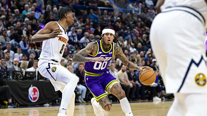 Jan 10, 2024; Salt Lake City, Utah, USA; Utah Jazz guard Jordan Clarkson (00) dribbles around Denver Nuggets guard Peyton Watson (8) during the second half at the Delta Center. Mandatory Credit: Christopher Creveling-Imagn Images