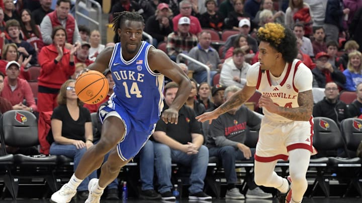 Dec 8, 2024; Louisville, Kentucky, USA;  Duke basketball guard Sion James (14) dribbles against Louisville Cardinals guard Chucky Hepburn (24) during the first half at KFC Yum! Center. Duke defeated Louisville 76-65.