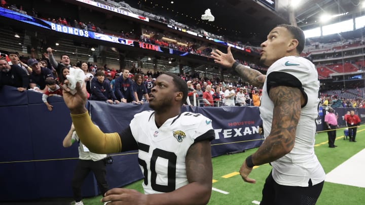 Nov 26, 2023; Houston, Texas, USA; Jacksonville Jaguars linebacker Shaquille Quarterman (50) and  tight end Evan Engram (17) throws their gloves to fans after defeating the Houston Texans at NRG Stadium. Mandatory Credit: Thomas Shea-USA TODAY Sports