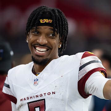 Washington Commanders quarterback Jayden Daniels (5) celebrates against the Arizona Cardinals at State Farm Stadium. Mandatory Credit: Mark J. Rebilas-Imagn Images