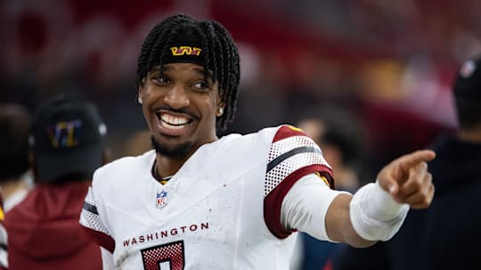 Washington Commanders quarterback Jayden Daniels (5) celebrates against the Arizona Cardinals at State Farm Stadium. Mandatory Credit: Mark J. Rebilas-Imagn Images