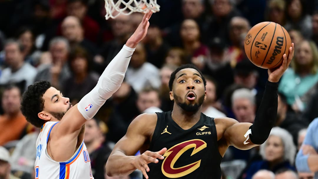 Jan 19, 2026; Cleveland, Ohio, USA; Cleveland Cavaliers guard Donovan Mitchell (45) drives to the basket against Oklahoma City Thunder guard Ajay Mitchell (25) during the second half at Rocket Arena. Mandatory Credit: Ken Blaze-Imagn Images
