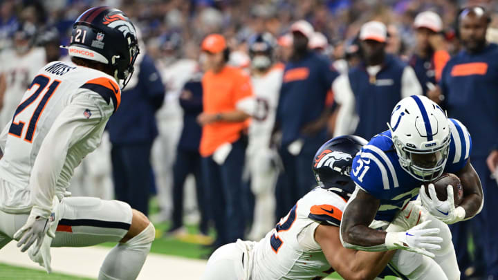 Aug 11, 2024; Indianapolis, Indiana, USA;  Indianapolis Colts running back Tyler Goodson (31) is tackled by Denver Broncos linebacker Jonah Elliss (52) during the first quarter at Lucas Oil Stadium. 