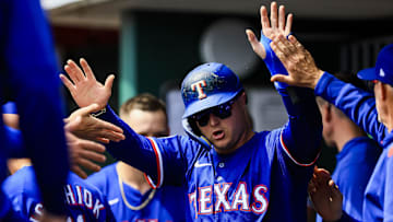 Apr 2, 2025; Cincinnati, Ohio, USA; Texas Rangers designated hitter Joc Pederson (4) high fives teammates after scoring on a RBI double hit by shortstop Josh Smith (not pictured) in the fourth inning against the Cincinnati Reds at Great American Ball Park.
