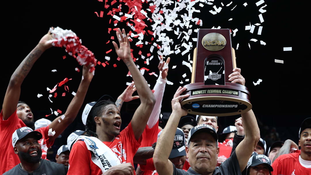 Houston Cougars head coach Kelvin Sampson holds the trophy on stage after defeating the Tennessee Volunteers during the Midwest Regional final of the 2025 NCAA tournament at Lucas Oil Stadium. 
