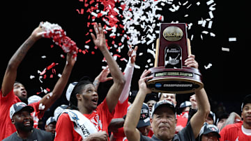 Houston Cougars head coach Kelvin Sampson holds the trophy on stage after defeating the Tennessee Volunteers during the Midwest Regional final of the 2025 NCAA tournament at Lucas Oil Stadium. 