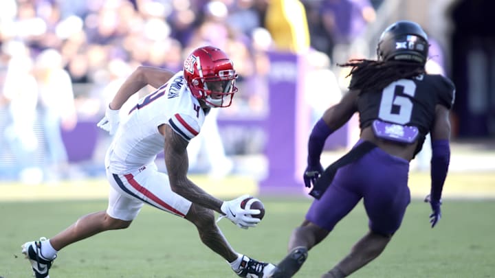 Nov 23, 2024; Fort Worth, Texas, USA; Arizona Wildcats wide receiver Tetairoa McMillan (4) runs with the ball against TCU Horned Frogs cornerback LaMareon James (6) in the second quarter at Amon G. Carter Stadium. Mandatory Credit: Tim Heitman-Imagn Images