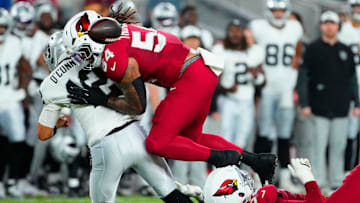 Cardinals edge rushers Jordan Burch (52) and Xavier Thomas (54) force a fumble on Raiders quarterback Aidan O’Connell (12) during a preseason game at State Farm Stadium in Glendale on Aug. 23, 2025.