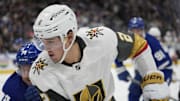 Nov 20, 2024; Toronto, Ontario, CAN; Vegas Golden Knights defenseman Zach Whitecloud (2) tries to control the puck against the Toronto Maple Leafs during the first period at Scotiabank Arena. Mandatory Credit: John E. Sokolowski-Imagn Images