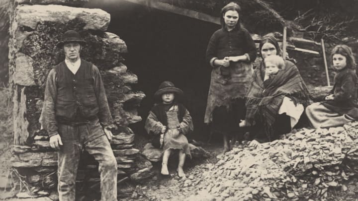 An Irish family at the ruins of their house In Killarney.