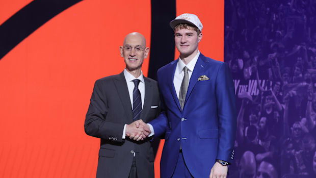 June 25, 2025; Brooklyn, NY, United States; Liam McNeeley stands with the NBA commissioner Adam Silver, after being selected as 29th photo