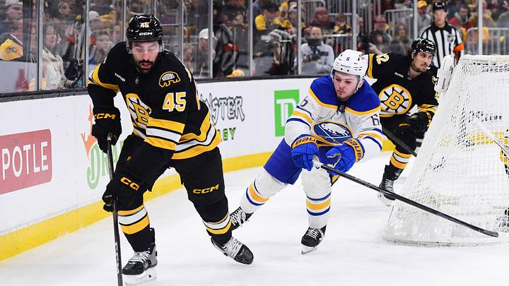 Apr 26, 2026; Boston, Massachusetts, USA;Boston Bruins defenseman Jonathan Aspirot (45) controls the puck from Buffalo Sabres left wing Zach Benson (6) during the second period in game four of the first round of the 2026 Stanley Cup Playoffs at TD Garden. Mandatory Credit: Bob DeChiara-Imagn Images