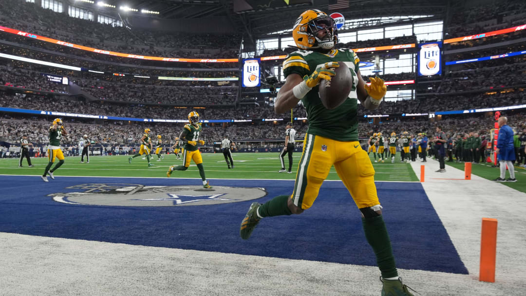 Green Bay Packers running back Aaron Jones (33) tosses the ball in the stands after scoring a