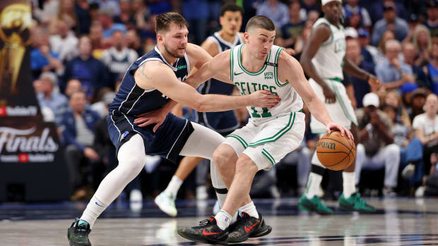 Boston Celtics guard Payton Pritchard dribbles the ball against Dallas Mavericks guard Luka Doncic.